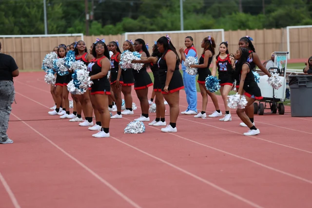The Madison cheer squad lined up beside the track with blue and white pom-poms.