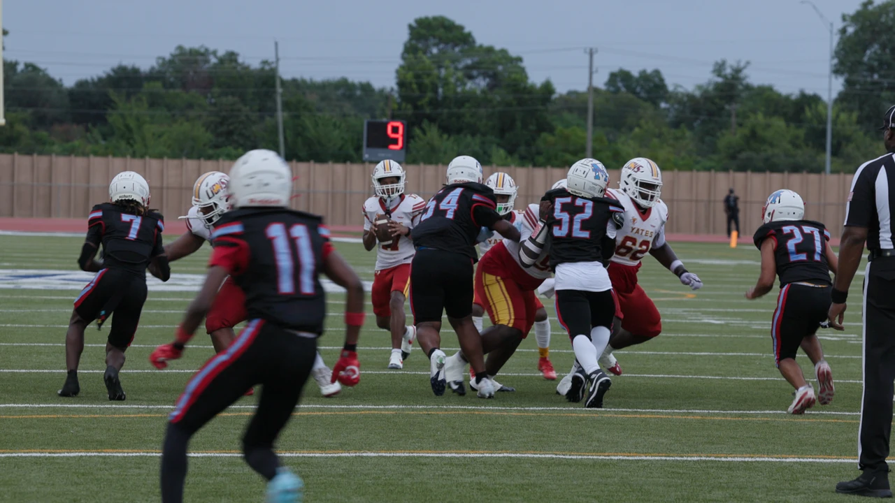 Madison players in black uniforms defending a play on the field.