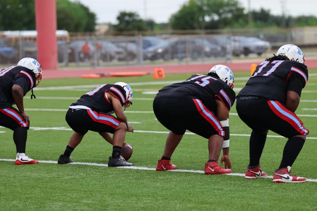 Madison linemen crouching in formation on the field.